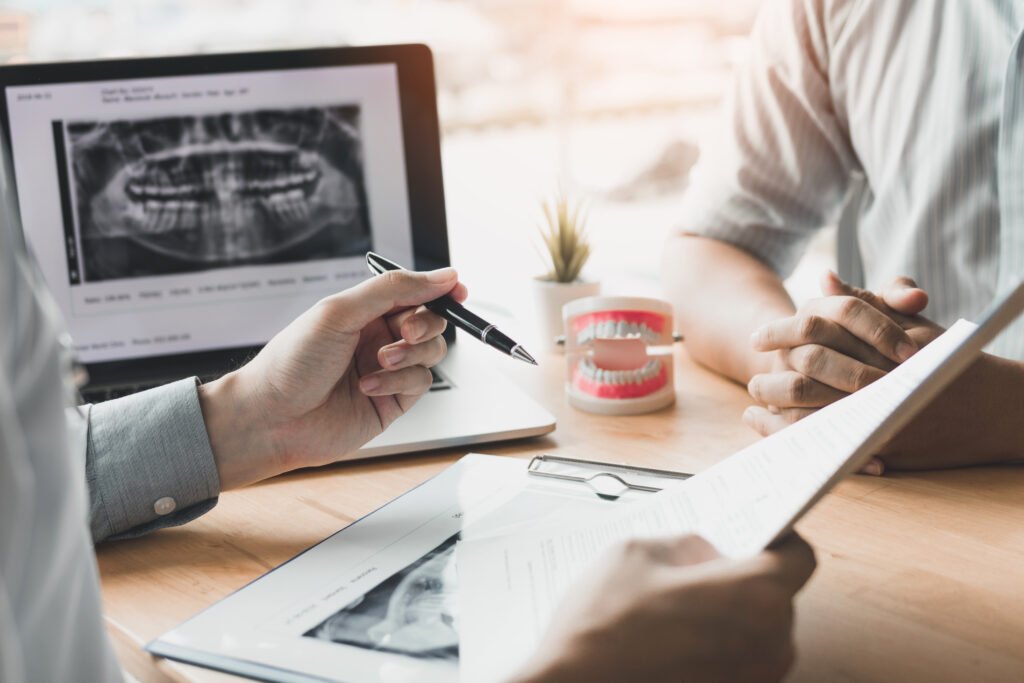 Dentist explaining a dental X-ray to a patient before root canal treatment